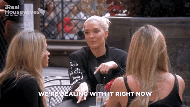 three women sitting at a table with the words " we 're dealing with it right now " on the bottom