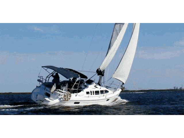 a sailboat with a flag on the side is floating on the water