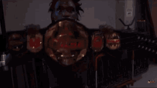 a man is holding up a belt that says impact on it