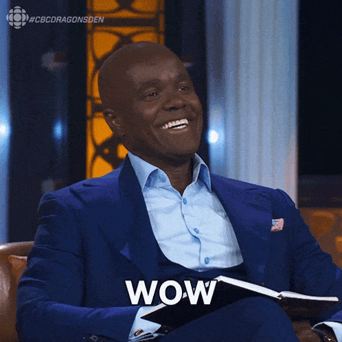 a man in a blue suit is holding a book and saying wow