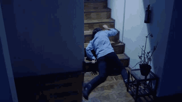 a man in a blue shirt is laying on the floor