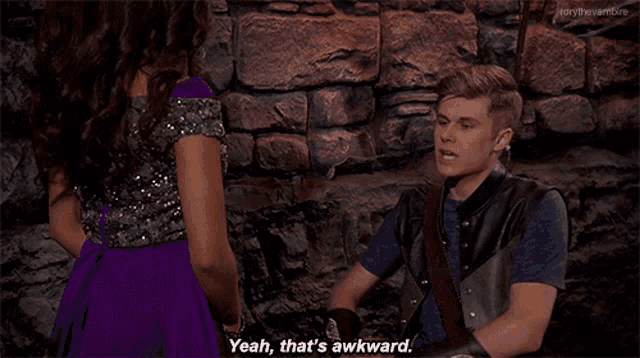 a man and a woman are sitting in front of a stone wall and the man says yeah that 's awkward