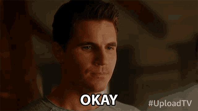 a man in a grey shirt says okay on the screen