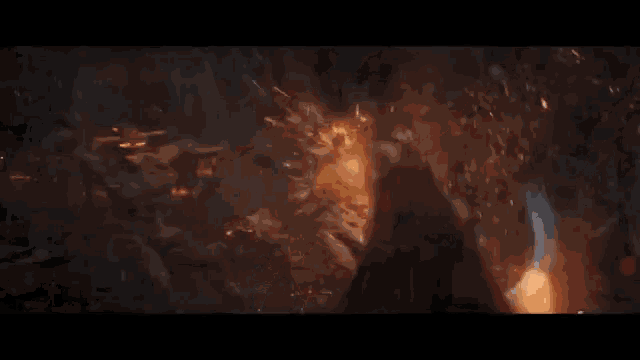 a close up of a person standing in a dark room with a fireball coming out of it .