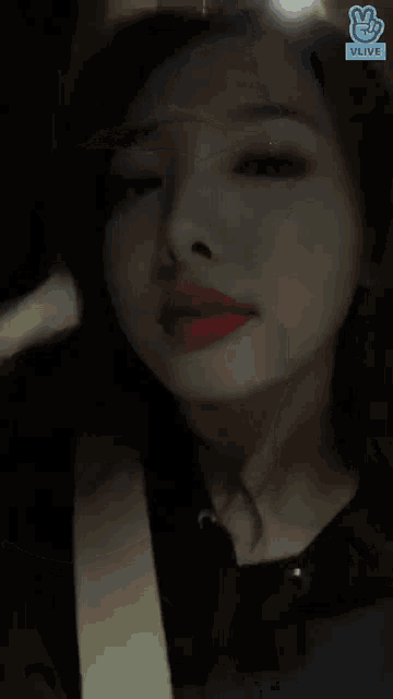 a close up of a woman 's face with a vlive icon in the corner
