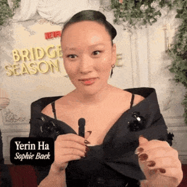 a woman is holding a brush in front of a sign for bridge season