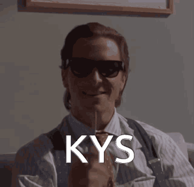a man wearing sunglasses and suspenders is holding a knife and the word kys is on the bottom right