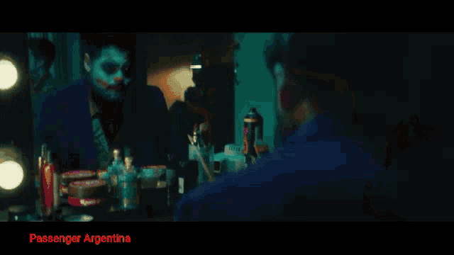 a group of people are dancing in a dark room with passenger argentina written on the bottom of the screen
