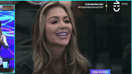 a woman is smiling in front of a purple sign that says casa en vivo