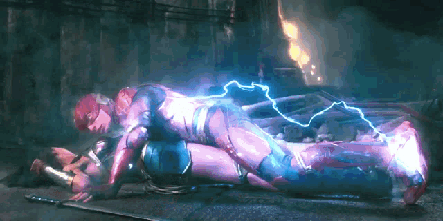 wonder woman is laying on the ground with the flash