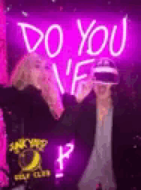 a couple of people are standing in front of a neon sign that says `` do you n't ? ''