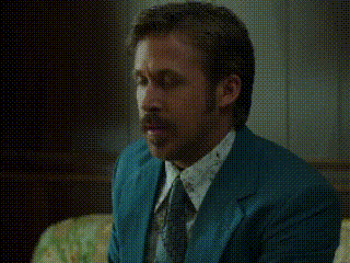 a man wearing a blue suit and tie is sitting on a couch .
