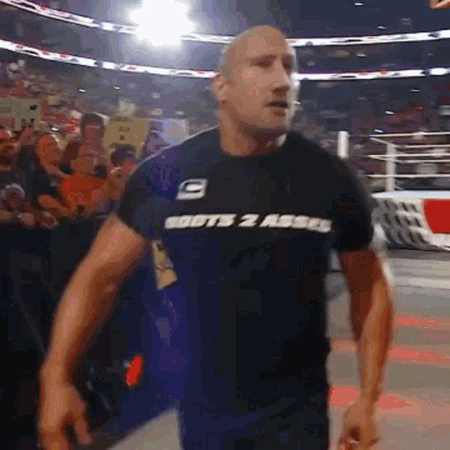 a man wearing a black shirt that says boots 2 asses