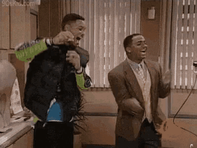 a couple of men are dancing together in a room in front of a window .