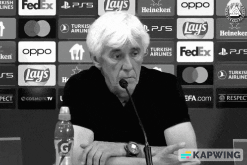 a man sitting in front of a microphone with a bottle of gatorade in his hand
