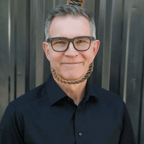 a man wearing glasses and a black shirt has a noose around his neck