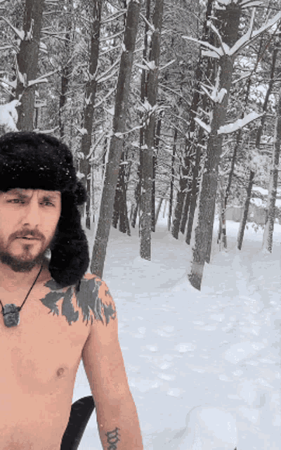 a man without a shirt is standing in the snow