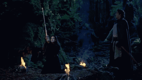 a woman in a black dress is holding a torch in her hand