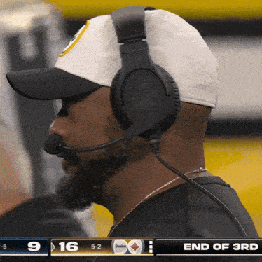 a man wearing headphones is watching a football game between the steelers and the bengals