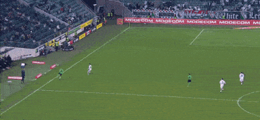 soccer players on a field with a sign that says modecom