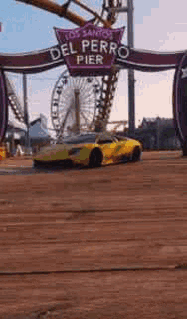 a yellow car is driving down a wooden dock in front of a roller coaster .