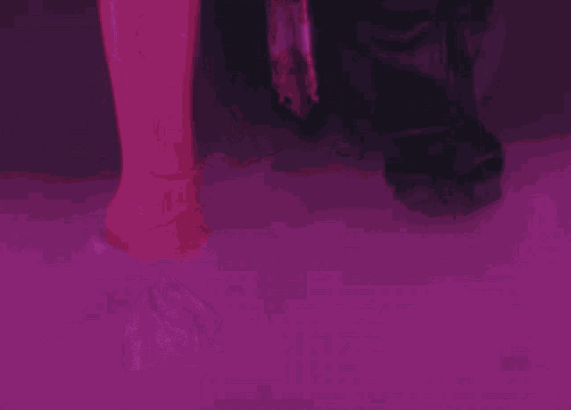 a woman 's feet are visible in a purple light