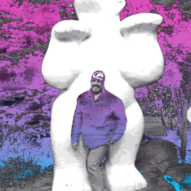 a man in a purple jacket is standing next to a statue of a woman