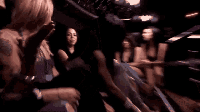 a group of people are dancing in a dark room at a party .