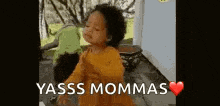 a little girl is dancing with the words `` yasss mommas '' .