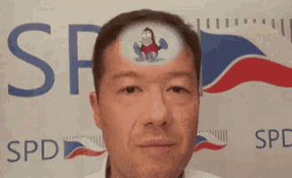 a man with a cartoon character on his forehead in front of a spd logo