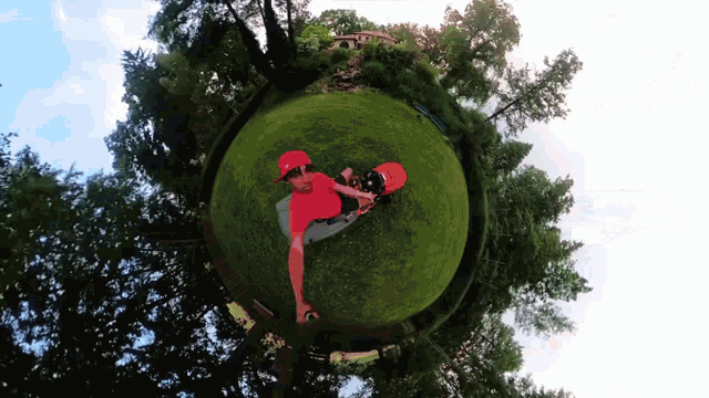 a man in a red hat is laying on a globe of grass