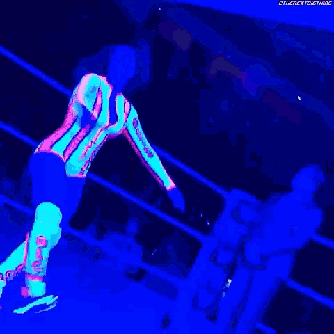 a glow in the dark wrestler is standing in a ring .