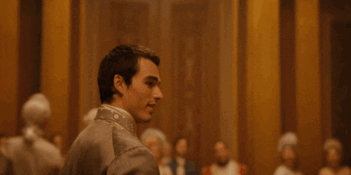 a man in a suit and tie is standing in a room