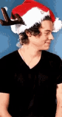a man wearing a santa hat with antlers on his head