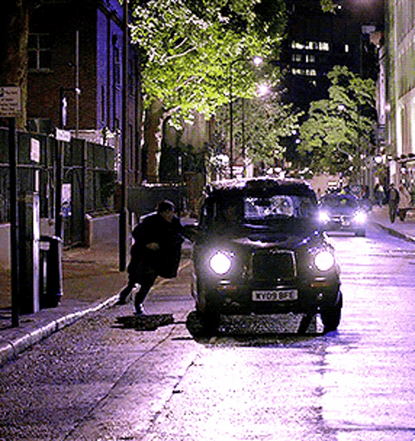 a car with license plate ky09 bfe is driving down a street at night