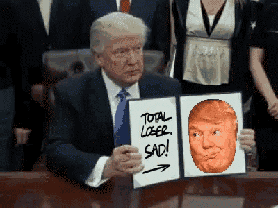 a man in a suit and tie is holding a sign that says " total loser sad "