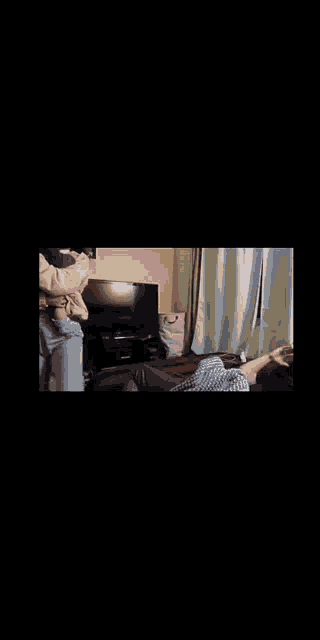 two women are hugging each other in a living room in a video .