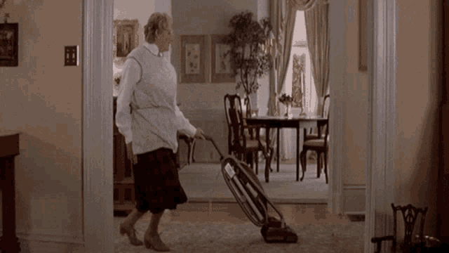 a woman is using a vacuum cleaner to clean a rug