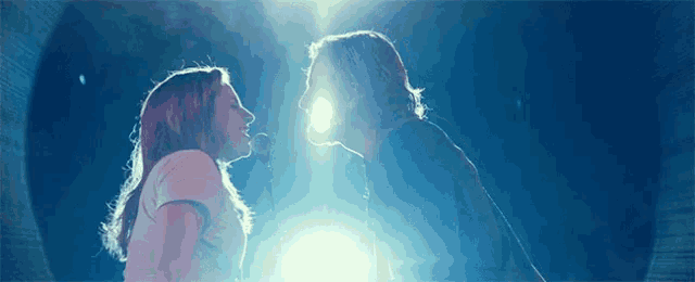 a man and a woman are singing into microphones in front of a blue background