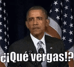 barack obama is giving a speech in front of an american flag and says ¿ que vergas ?
