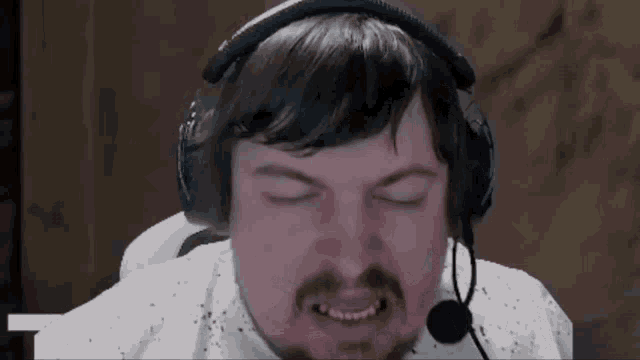 a man with a mustache is wearing headphones and a microphone .
