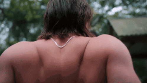 the back of a shirtless man wearing a silver chain