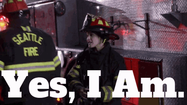 a seattle firefighter stands in front of a fire truck and says yes i am