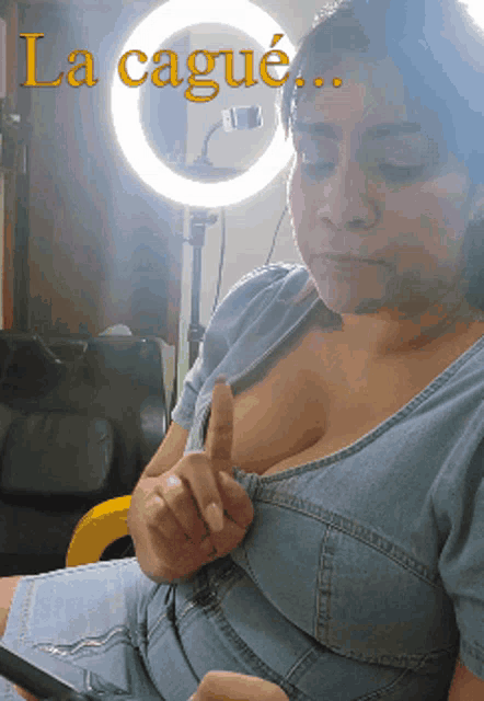 a woman is sitting in front of a ring light and the words la cague are on the bottom
