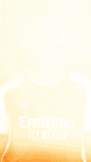 a woman wearing a red emirates fly better jersey smiles