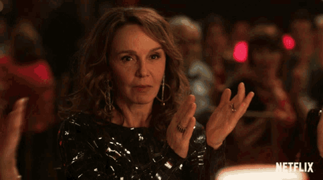 a woman is clapping her hands in front of a netflix sign