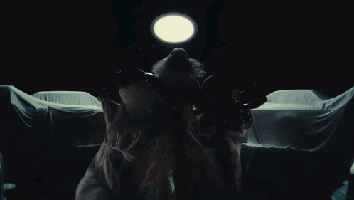a woman in a white dress is dancing in front of a light