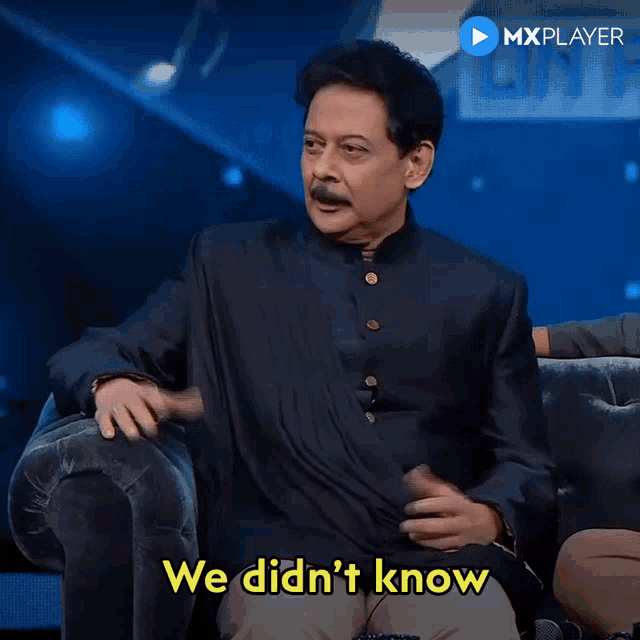 a man is sitting on a couch with the words we did n't know above him