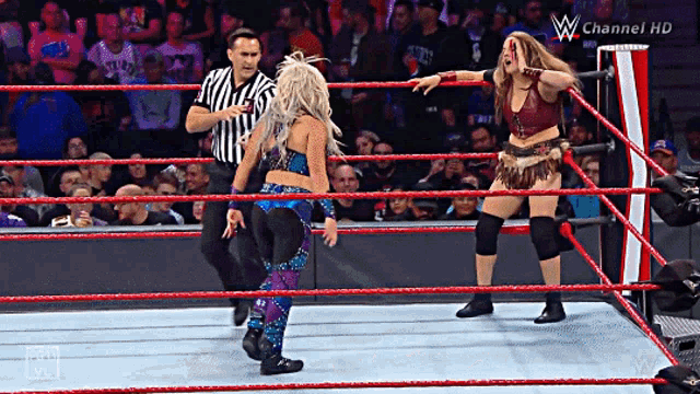 two women are wrestling in a ring with a referee and the words w channel hd on the bottom right