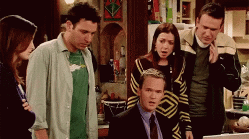 a group of people are standing around a man in a suit and tie .